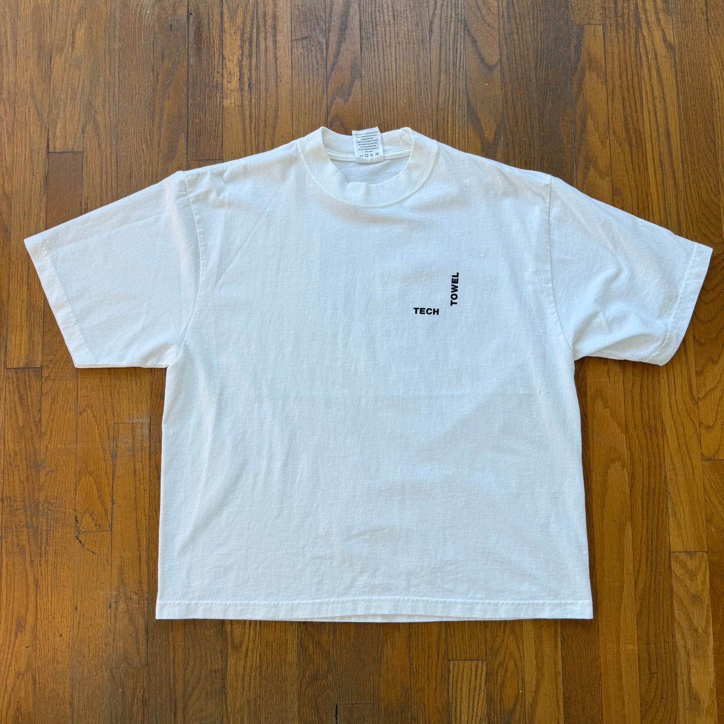 White t-shirt with text on a wooden floor
